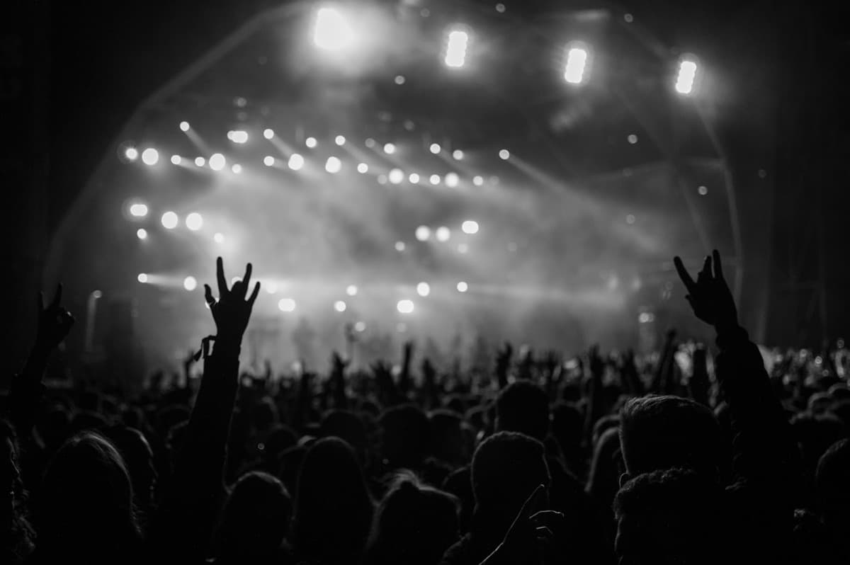 Festival crowd, hands up against the stage lights